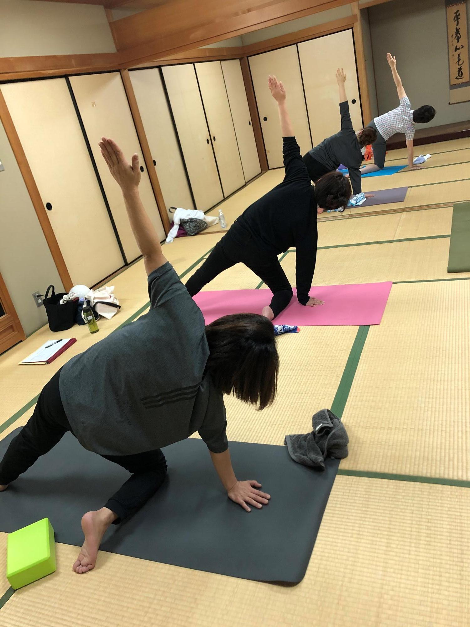 和室で少人数でヨガを行っている様子の写真