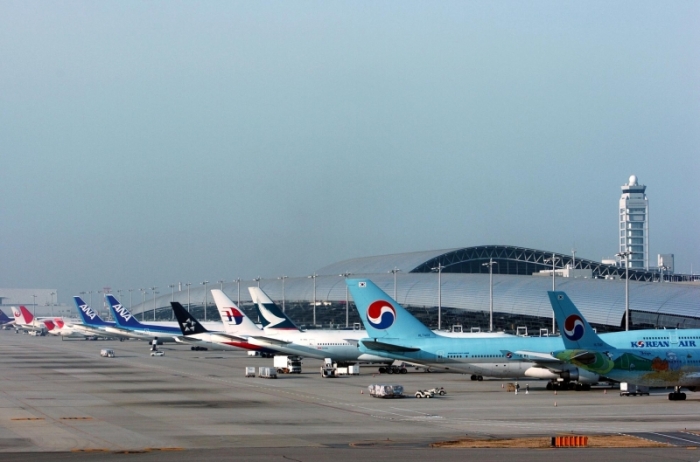 いろいろな航空会社の飛行機が並んでいる関西国際空港の駐機場の写真