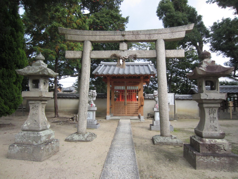 石碑が両端にあり、中央に鳥居、奥にお社が見える春日神社の写真