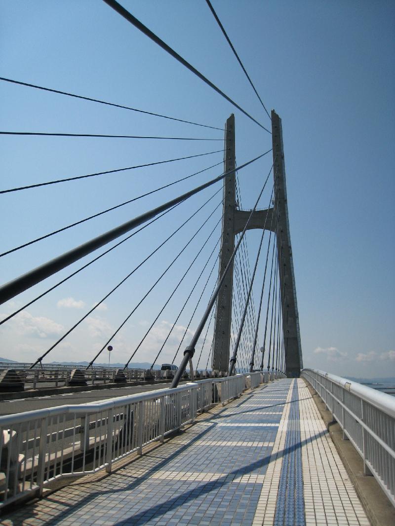 塔から斜めに張ったケーブルを橋桁に直接つなぎ支える構造の田尻スカイブリッジを歩道から写した写真