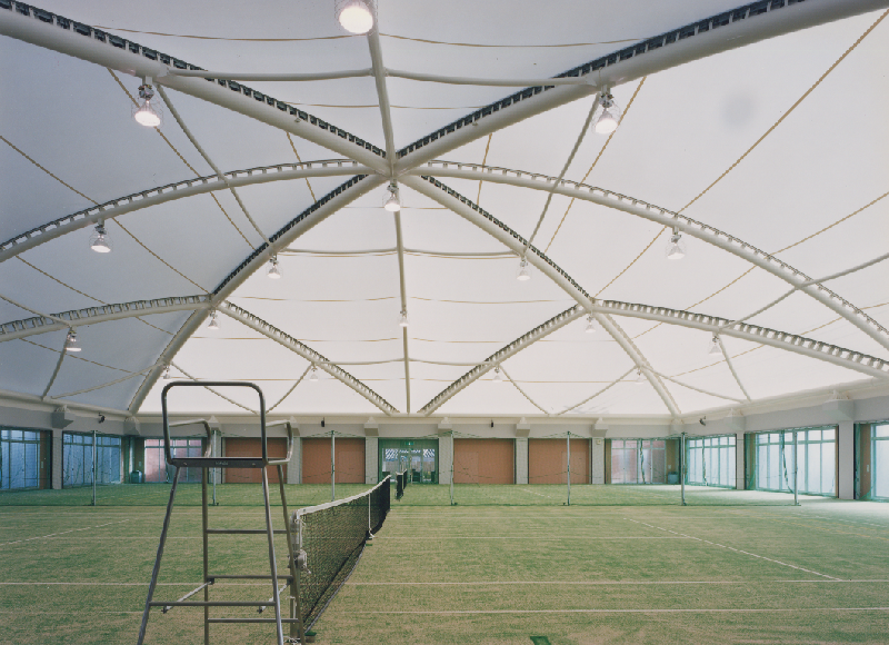 天井が球体のような造りをした芝のテニスコートを横から写した写真