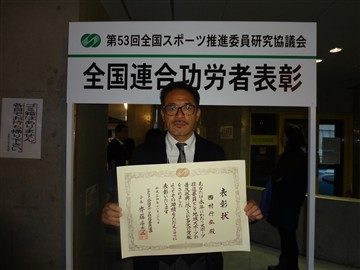 功労者表彰受賞で表彰状を持ち記念撮影をしている西村行弘氏の写真