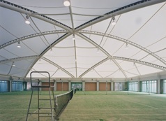 天井が球体のような造りをした芝のテニスコートを横から写した写真