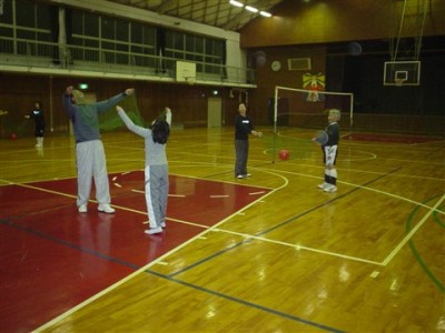 体育館の中で2人1組でボールを使ったスポーツを楽しんでいる4名の人達の写真