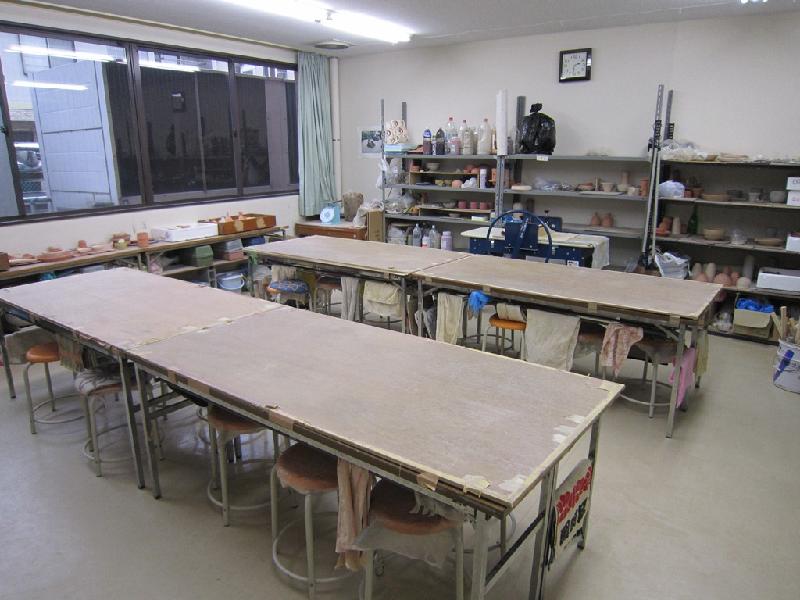 大きな陶芸ができる机が2つ平行に置かれている陶芸室の写真