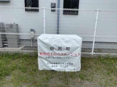 田尻町緊急用土のうステーションと書かれた白色のカバーが掛けられている写真