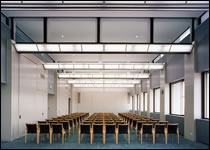 広々とした室内に、左に3客 中央に4脚、右に3脚の横一列に並んだ椅子が前方からずらりと並んでいる研修室の写真