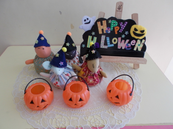 Happy Halloweenと書かれた手作りの飾りや三角帽子をかぶった動物の人形、かぼちゃのランタンのおもちゃの写真