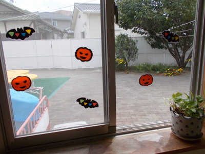 ガラス窓に貼られたかぼちゃやこうもりの飾りの写真