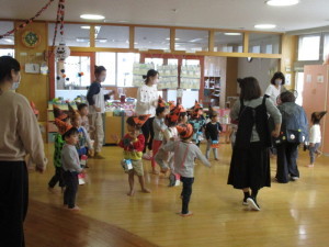 オレンジ色の三角帽子をかぶってダンスをしている子供たちの写真