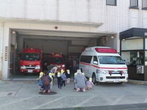 消防署の救急車や消防車を見学している園児と先生の写真
