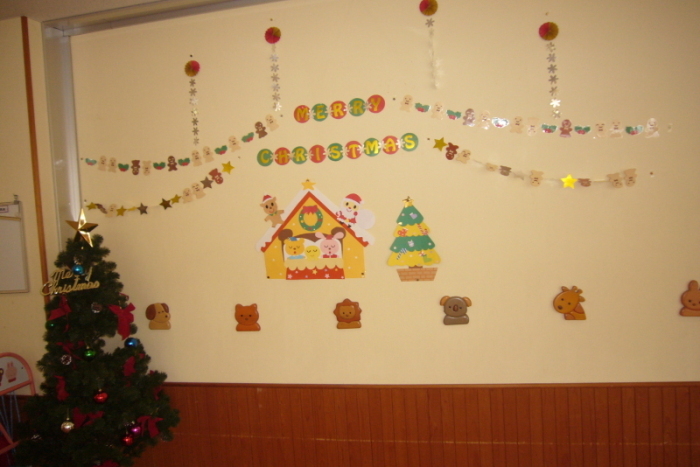 クリスマスの飾りつけがされている壁とクリスマスツリーの写真