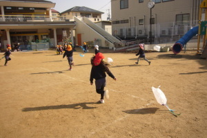 凧をもって園庭を走っている園児たちの写真