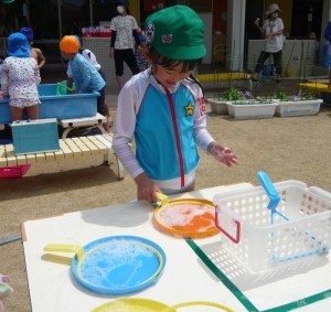 シャボン玉で遊んでいる園児の写真