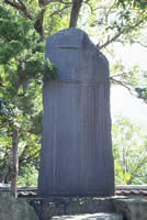 長方形で頂上が不揃いに斜めになっている泉州玉葱栽培の祖碑の写真