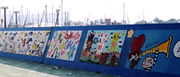 堤防の壁に様々な絵が描かれたウォールペインティングの写真